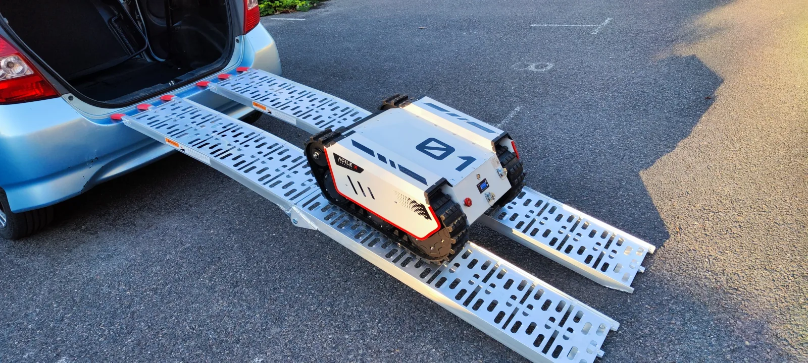 BUNKER MINI 2.0 fährt über Rampen aus dem Kofferraum eines Pkw