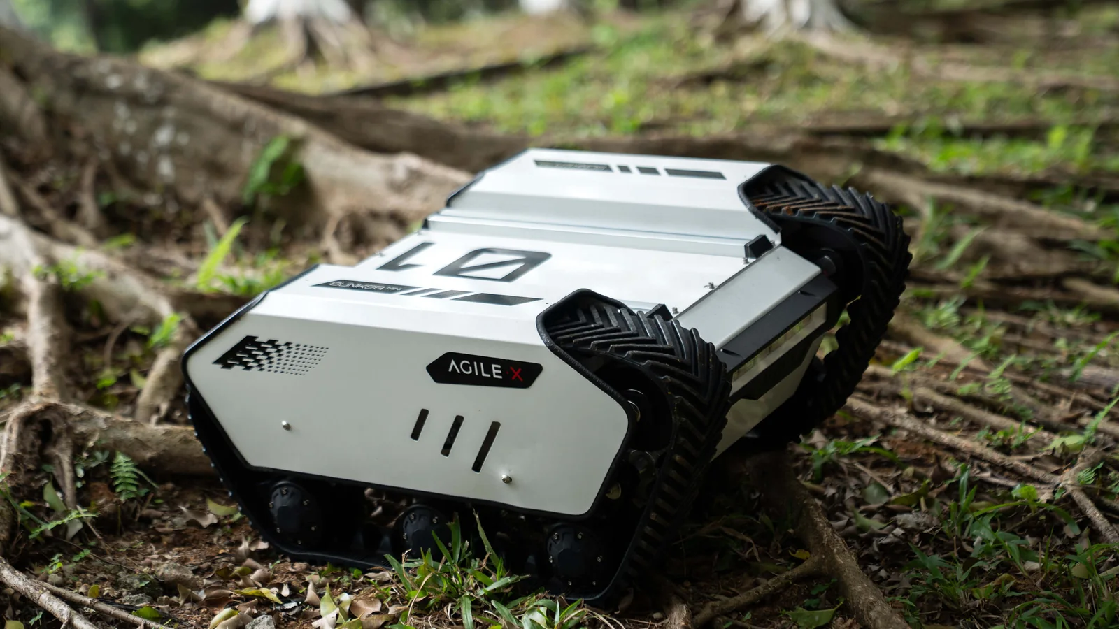 BUNKER MINI 2.0 auf dem Waldboden zwischen Baumwurzeln - kompakte Kettenplattform (Herstellerfoto)