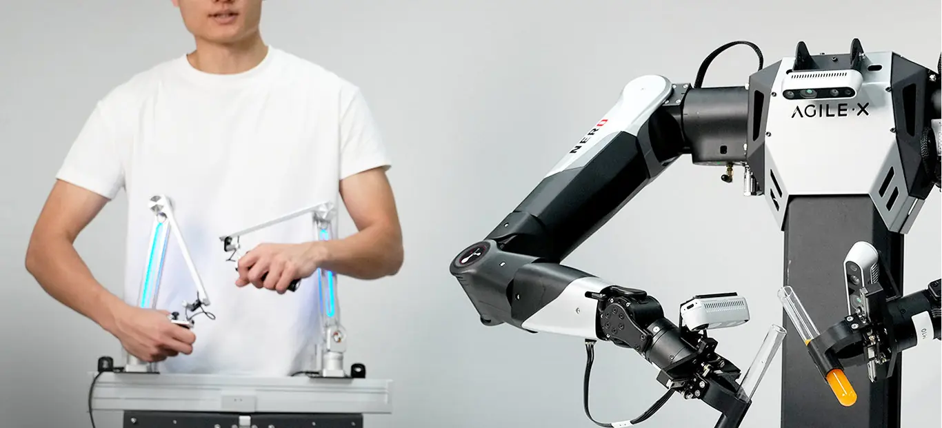 Universal Master Arm - Teleoperationsplatz: Bediener steuert mit zwei Führungsarmen einen zweiarmigen Roboter